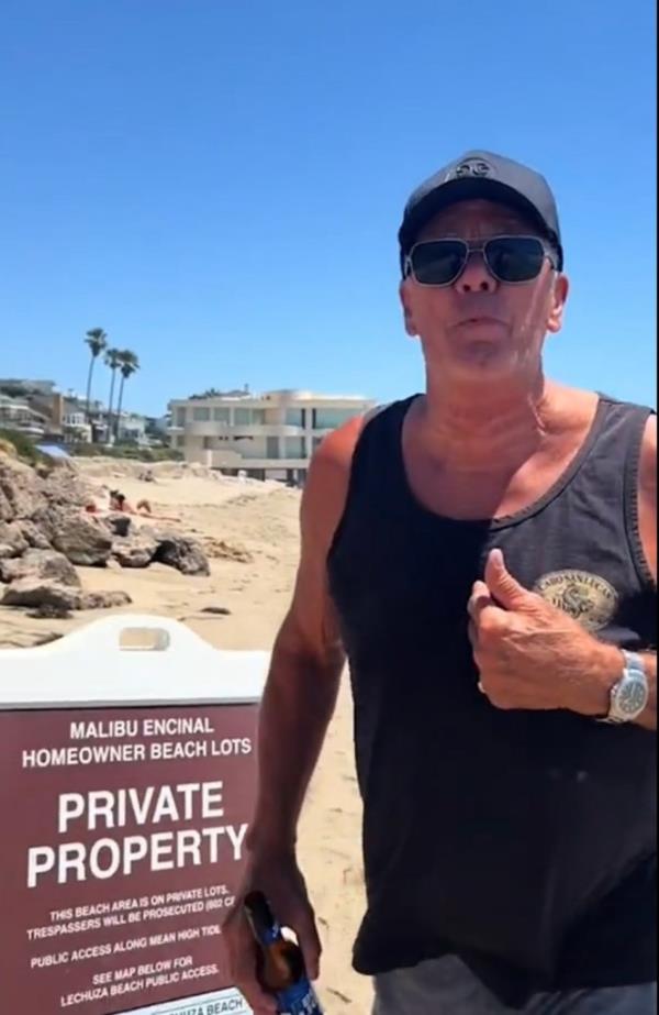 A screenshot from the TikTok clip showing the man in sunglasses objecting to people being on the beach.