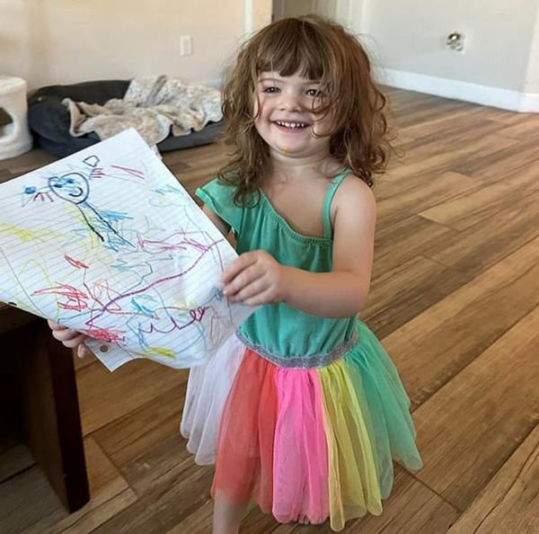 A 2-year-old girl named Parker holding a piece of paper