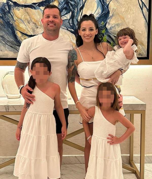 Christopher and Erika Scholtes posing for a picture with their two daughters